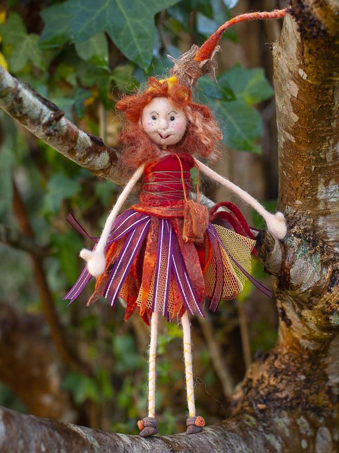 wool felted textile fairy art in a tree